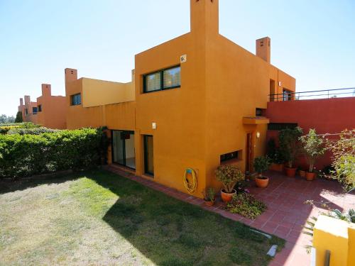 a large orange house with plants in a yard at Holiday Home Vistamar by Interhome in Ferrán