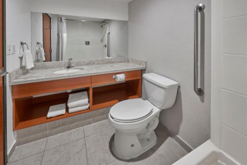 a bathroom with a white toilet and a sink at Extended Suites Monterrey Aeropuerto in Monterrey