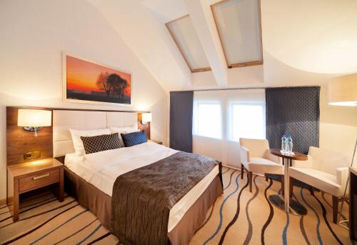 a bedroom with a bed and a desk and a window at Słoneczny Zdrój Medical Spa & Wellness in Busko-Zdrój