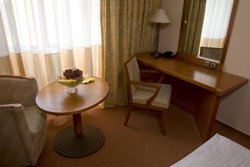 a room with a desk and a table with a bowl of fruit at Dr. Adler Spa & Kurhotel in Františkovy Lázně