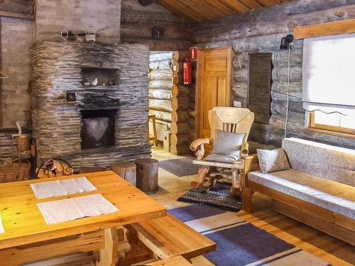 ein Wohnzimmer mit Kamin in einer Blockhütte in der Unterkunft Holiday Home Rukakolo by Interhome in Ruka