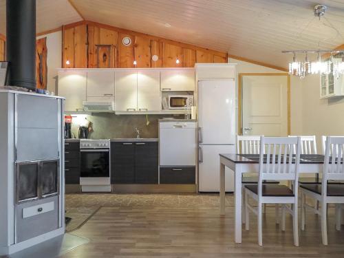 - une cuisine avec des appareils blancs, une table et des chaises dans l'établissement Holiday Home Aarre b by Interhome, à Saariselka
