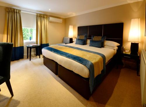 a large bedroom with a large bed with blue pillows at Rocpool Reserve Hotel & Restaurant in Inverness
