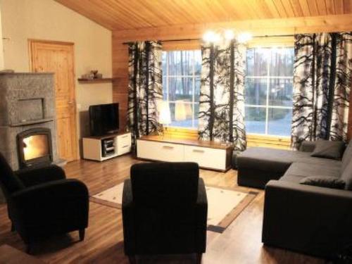 a living room with a couch and a fireplace at Holiday Home Akanlampi by Interhome in Karvonen
