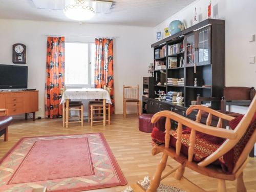 uma sala de estar com um sofá, uma cadeira e uma televisão em Holiday Home Levin mummola by Interhome em Köngäs