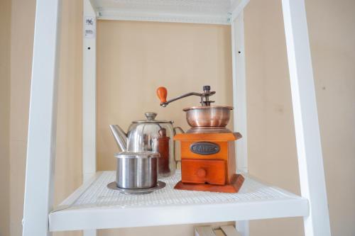 einen orangenen Mixer, der in einer Küche auf einem Regal sitzt in der Unterkunft Larasmita Cisitu by Zenrra House in Bandung