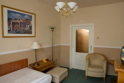 a bedroom with a bed and a table and a chair at Dr. Adler Spa & Kurhotel in Františkovy Lázně