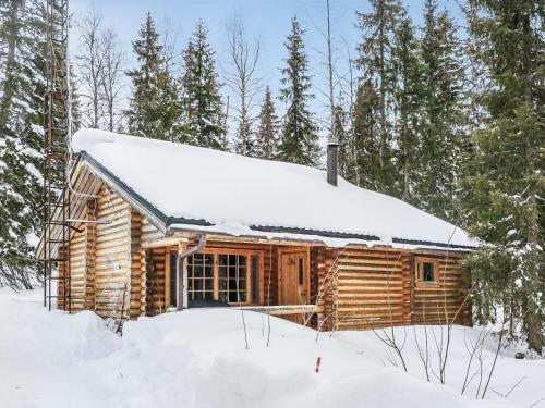 ルオストにあるHoliday Home Lähde by Interhomeの雪の森の丸太小屋
