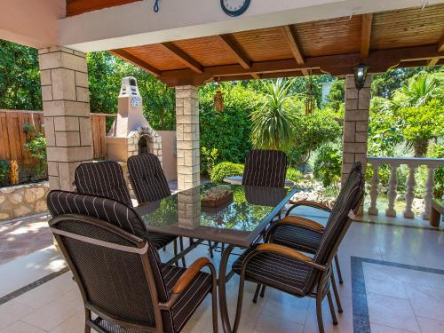 un patio con mesa y sillas en un porche en Holiday Home Patrizia Classic, en Selce
