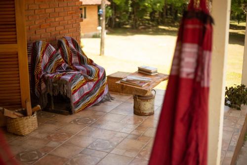 a chair and a coffee table on a patio at Chalés Recanto da cachoeira in Monte Verde