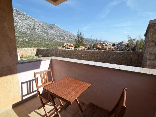 a wooden table and two chairs on a balcony at Apartment Golub-2 by Interhome in Cesarica