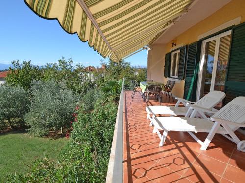 a patio with white chairs and an umbrella at Holiday Home Jelka by Interhome in Njivice