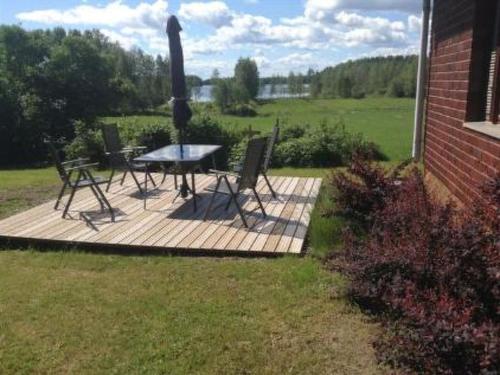 a table and chairs on a wooden deck in a yard at Holiday Home Jokela by Interhome in Horonkylä
