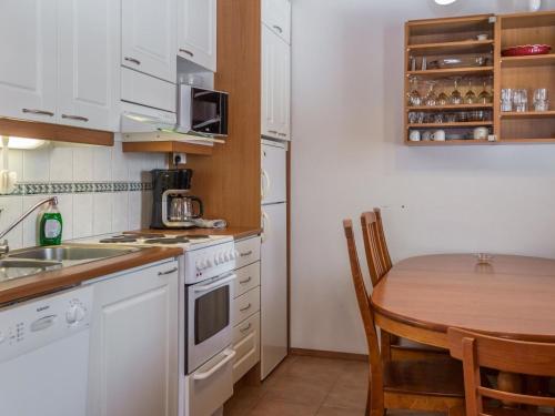 a kitchen with a table and a kitchen with white appliances at Holiday Home Peiponpesä b by Interhome in Tahkovuori