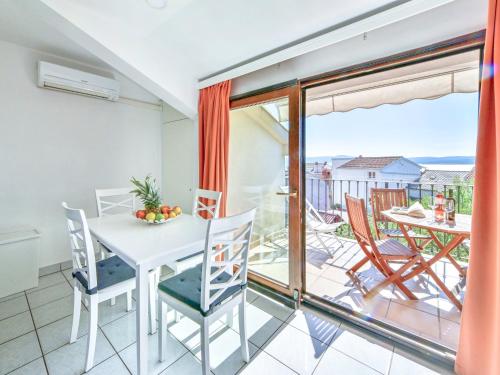 a dining room with a table and chairs and a balcony at Apartment Damir-2 by Interhome in Crikvenica