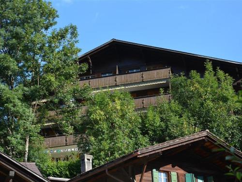 ein Apartmenthaus mit Bäumen davor in der Unterkunft Apartment Hübeli - Arm by Interhome in Zweisimmen
