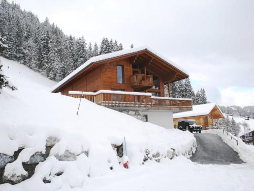 una baita di tronchi nella neve con vialetto di Apartment Nubes- Chalet by Interhome a Zweisimmen