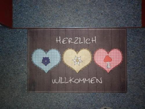 a sign with four hearts on it with the words hello willreon at Apartment Kronenplatz 7 # 3 by Interhome in Lenk
