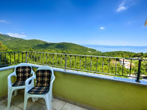 two chairs sitting on a balcony overlooking the ocean at Apartment Villa Tara-2 by Interhome in Brseč