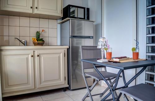 a kitchen with a table and a refrigerator at Hotel Pelican in Schœlcher