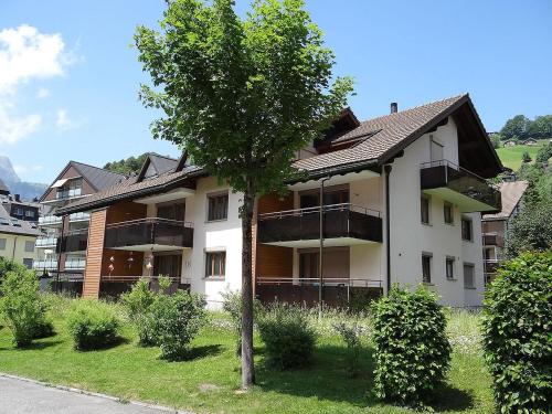 ein Gebäude mit Balkonen und einem Baum im Hof in der Unterkunft Apartment Blumenweg 2 by Interhome in Engelberg