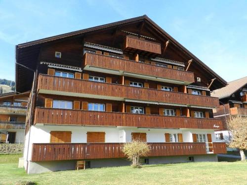 - un grand bâtiment avec des balcons sur le côté dans l'établissement Apartment Monique Nr- 14 by Interhome, à Gstaad