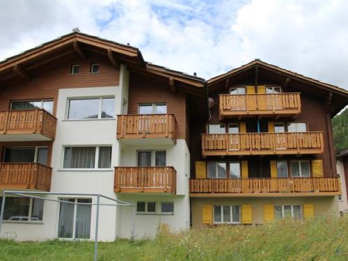 ein Apartmenthaus mit Holzbalkonen darauf in der Unterkunft Apartment Weideli by Interhome in Saas-Grund