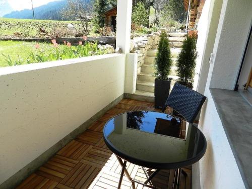 una mesa pequeña y una silla en un porche con vistas en Apartment Bijou Arnensee by Interhome, en Gsteig