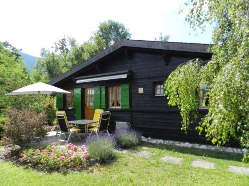 Cabaña verde y negra con mesa y sillas en Apartment Abnaki- Chalet by Interhome en Gstaad