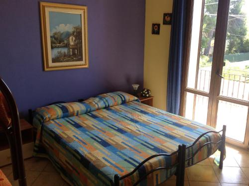 1 dormitorio con 1 cama en una habitación con ventana en Villa Marco Polo, en Fanusa