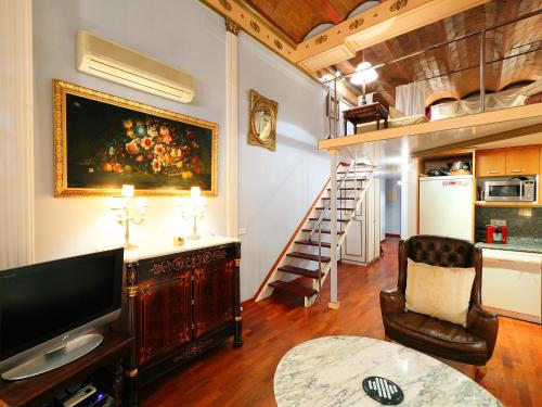 a living room with a television and a stair case at Apartment Plaza de Catalunya - Pso- de Gracia by Interhome in Barcelona