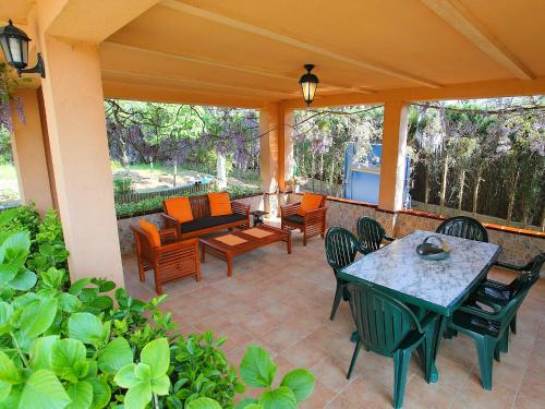 um pátio exterior com uma mesa e cadeiras em Holiday Home Marina by Interhome em Vidreres