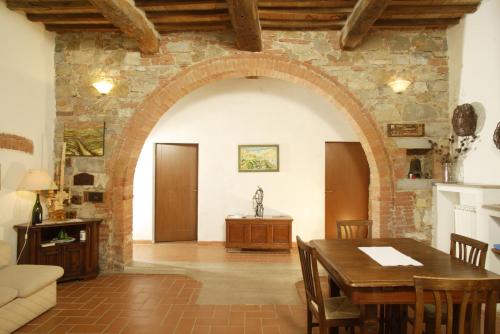 a living room with a table and a stone wall at Podere Il Tigliolo in Castiglione dʼOrcia