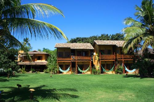 un complejo con palmeras delante en Pousada Ponta do Muta en Barra Grande
