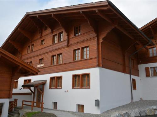 a large building with a wooden roof at Apartment Anne - Tiefparterre by Interhome in Gstaad