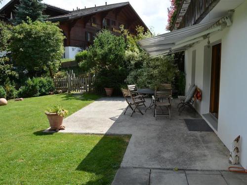 d'une terrasse avec des chaises et une table dans la cour. dans l'établissement Apartment Sambi by Interhome, à Gstaad