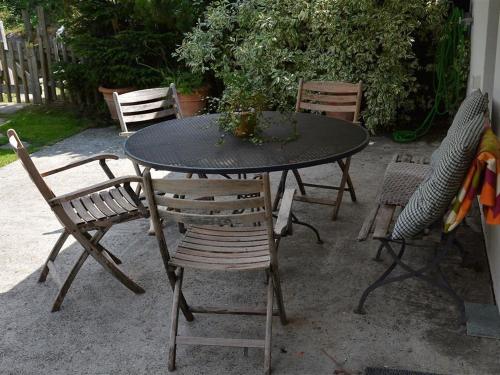 un tavolo nero con sedie e un tavolo con fiori di Apartment Sambi by Interhome a Gstaad