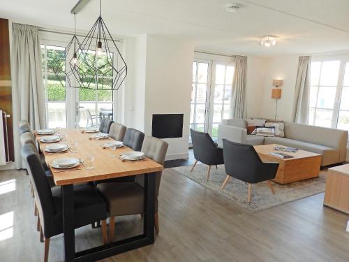 een eetkamer en een woonkamer met een tafel en stoelen bij Holiday Home de Witte Raaf-1 by Interhome in Noordwijkerhout