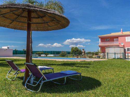 a table and two chairs under a umbrella at Villa Das Amendoeiras by Interhome in Estevais