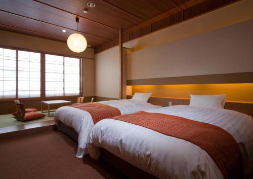 Llit o llits en una habitació de Ogoto Onsen Yunoyado Komolebi