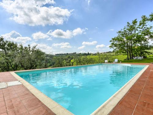 a large swimming pool with blue water at Apartment Chiantishire retreat-5 by Interhome in Barberino di Val dʼElsa
