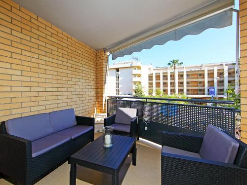 a balcony with a couch and a table and chairs at Apartment Can Pavet by Interhome in Vilafortuny
