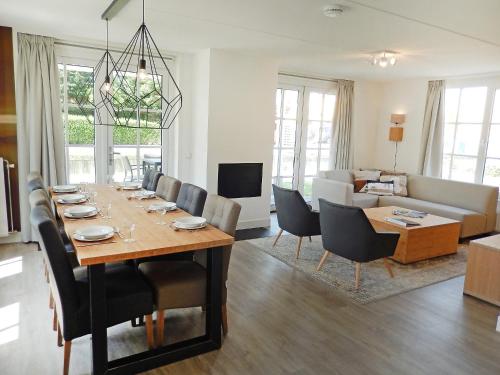 een eetkamer en woonkamer met een tafel en stoelen bij Holiday Home Alk 6 by Interhome in Noordwijk