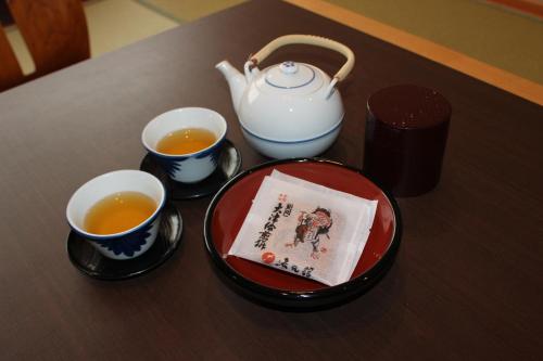a table with two cups of tea and a teapot at Ogoto Onsen Yunoyado Komolebi in Otsu