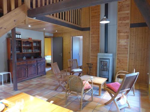 a living room with a table and chairs and a fireplace at Holiday Home Lac et Forêt by Interhome in Le Moutchic