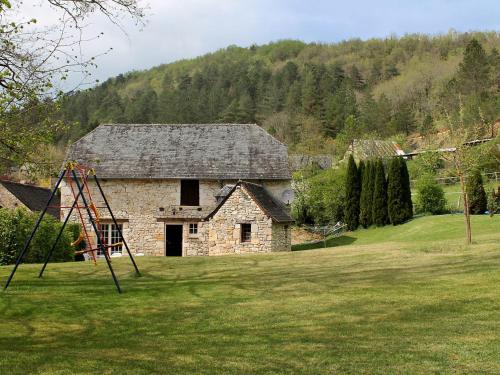 una casa in pietra con parco giochi in un cortile di Holiday Home La Colinoise by Interhome a Coly