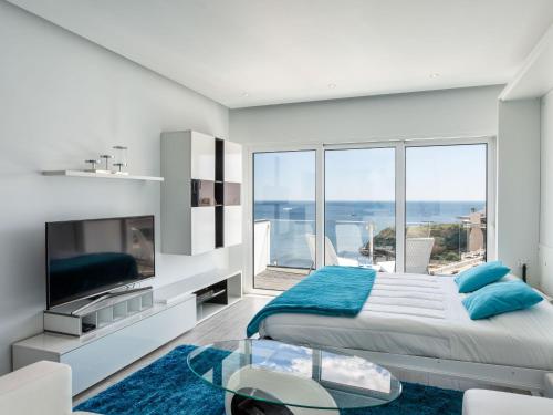 a white bedroom with a large bed and a large window at Studio Dream View 50m from the beach by Interhome in Albufeira