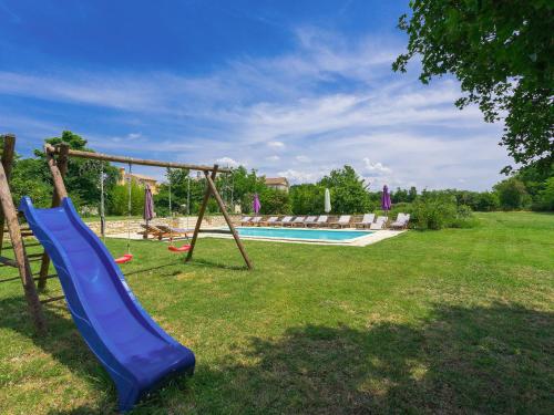 a playground with a blue slide and a pool at Villa Stancija Negrin by Interhome in Krnjaloža