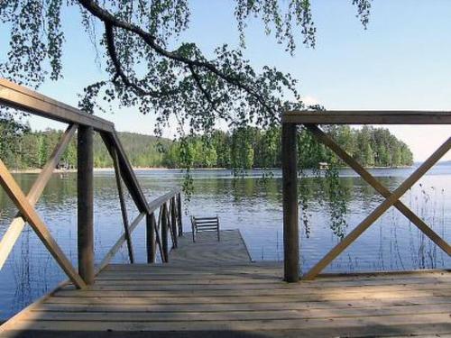 a wooden bridge over a lake with a bench on it at Holiday Home Hannala by Interhome in Muurame