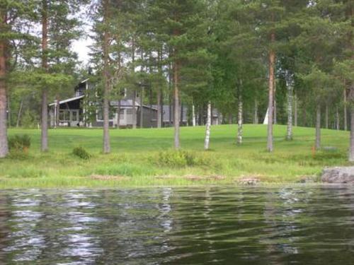 une maison assise sur la rive d'une masse d'eau dans l'établissement Holiday Home Paltamon golfhovi b by Interhome, à Paltamo